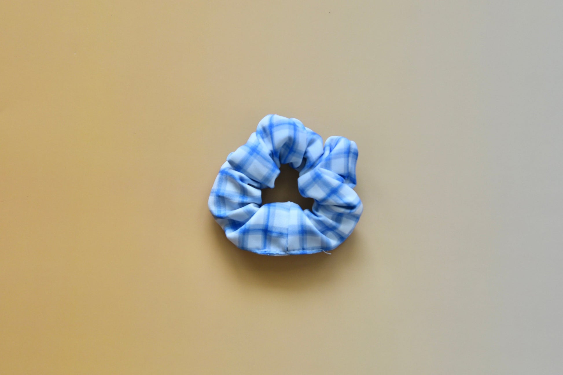 Blue scrunchie on a beige background