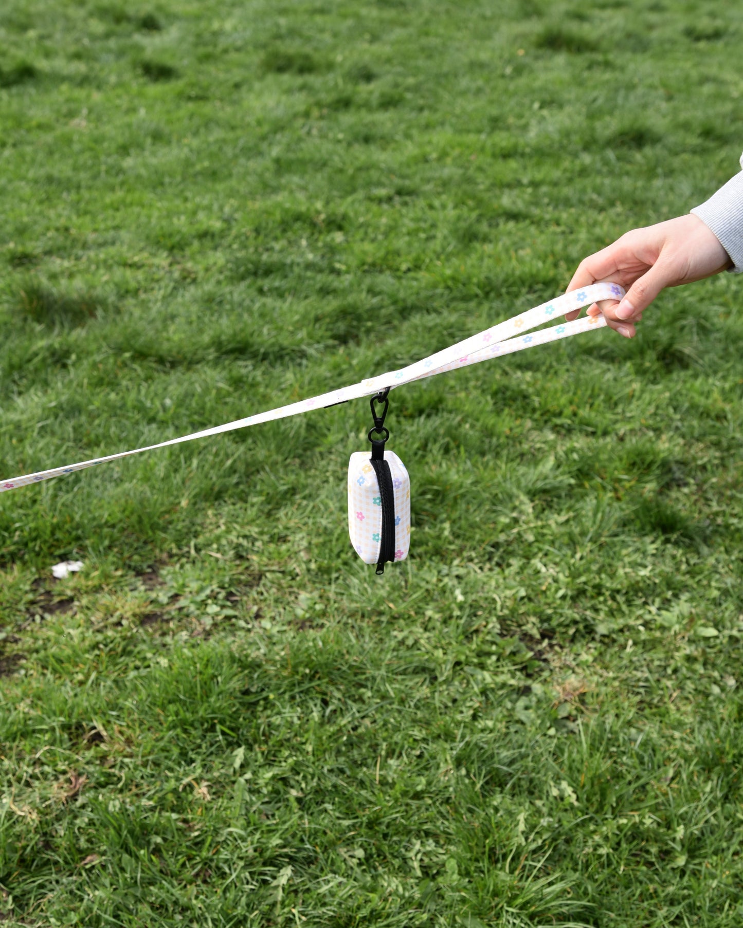 Person holding a white stick with a black and white object on a grassy field