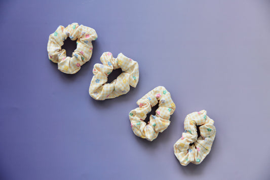 Four colorful scrunchies on a purple background