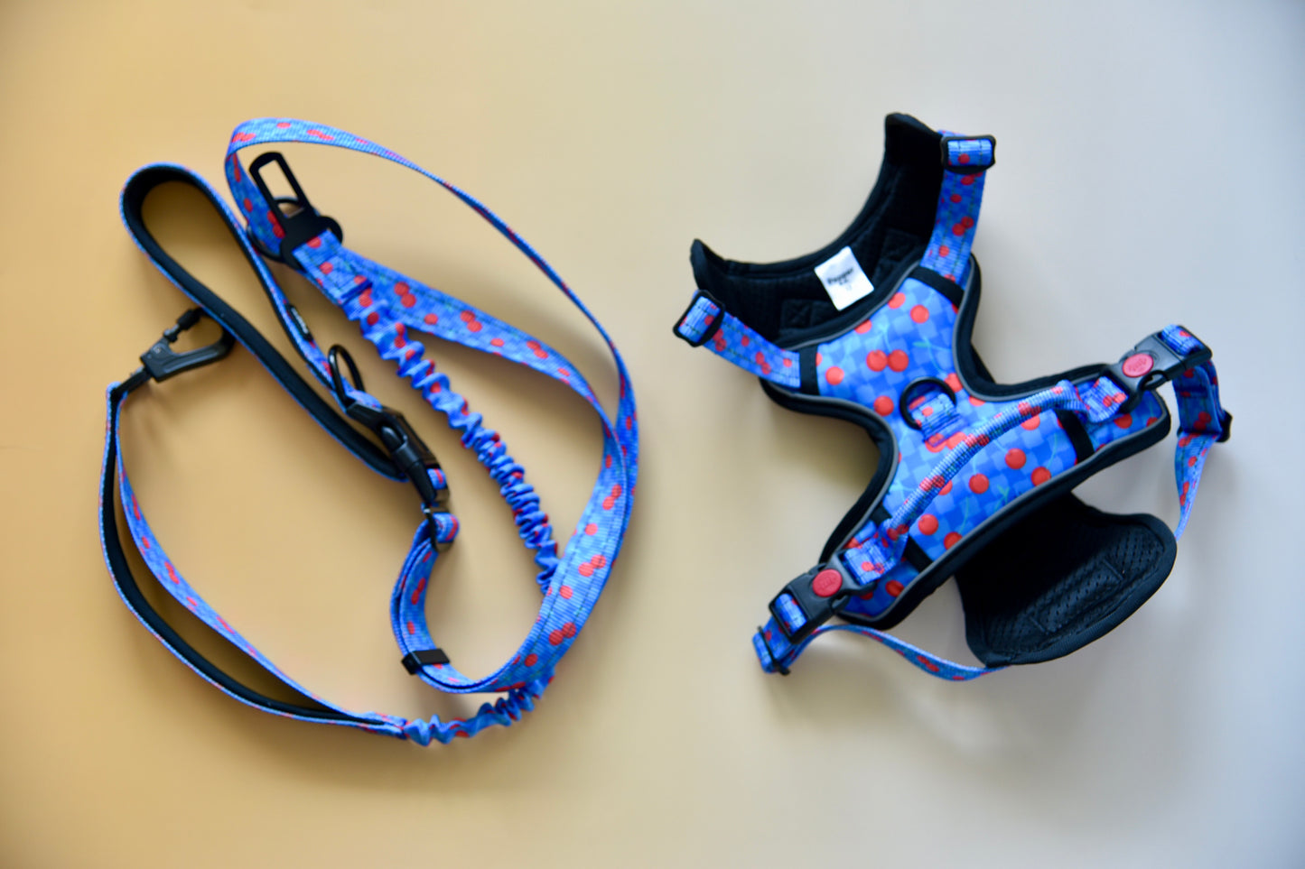 Dog harness and leash set with blue and black pattern on a beige background