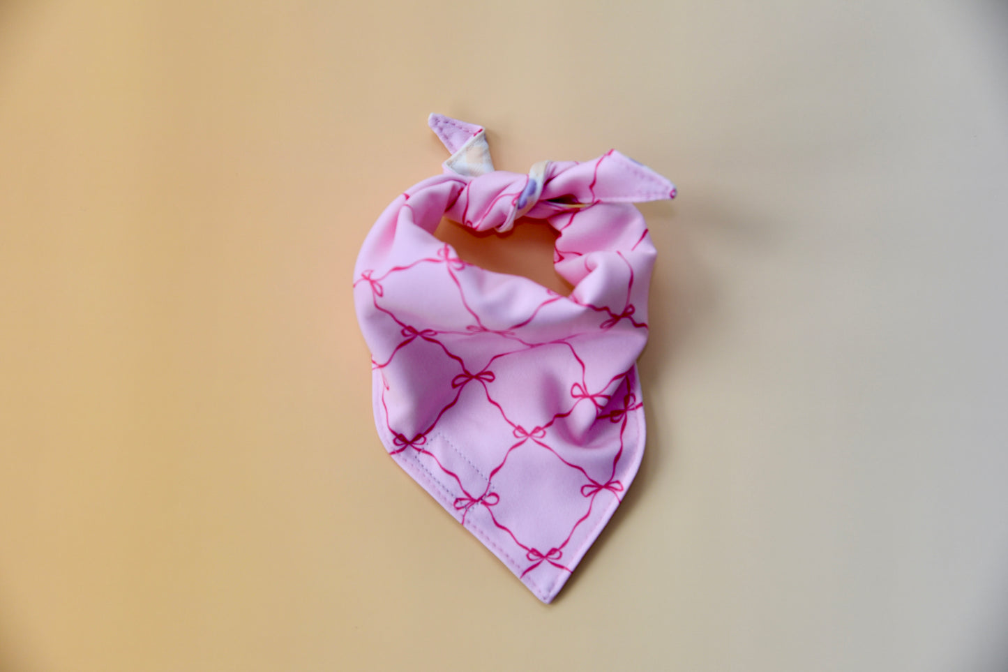 Pink bandana with bow pattern on a yellow background