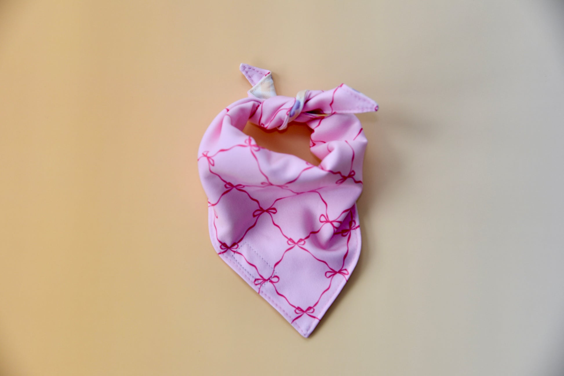 Pink bandana with bow pattern on a yellow background