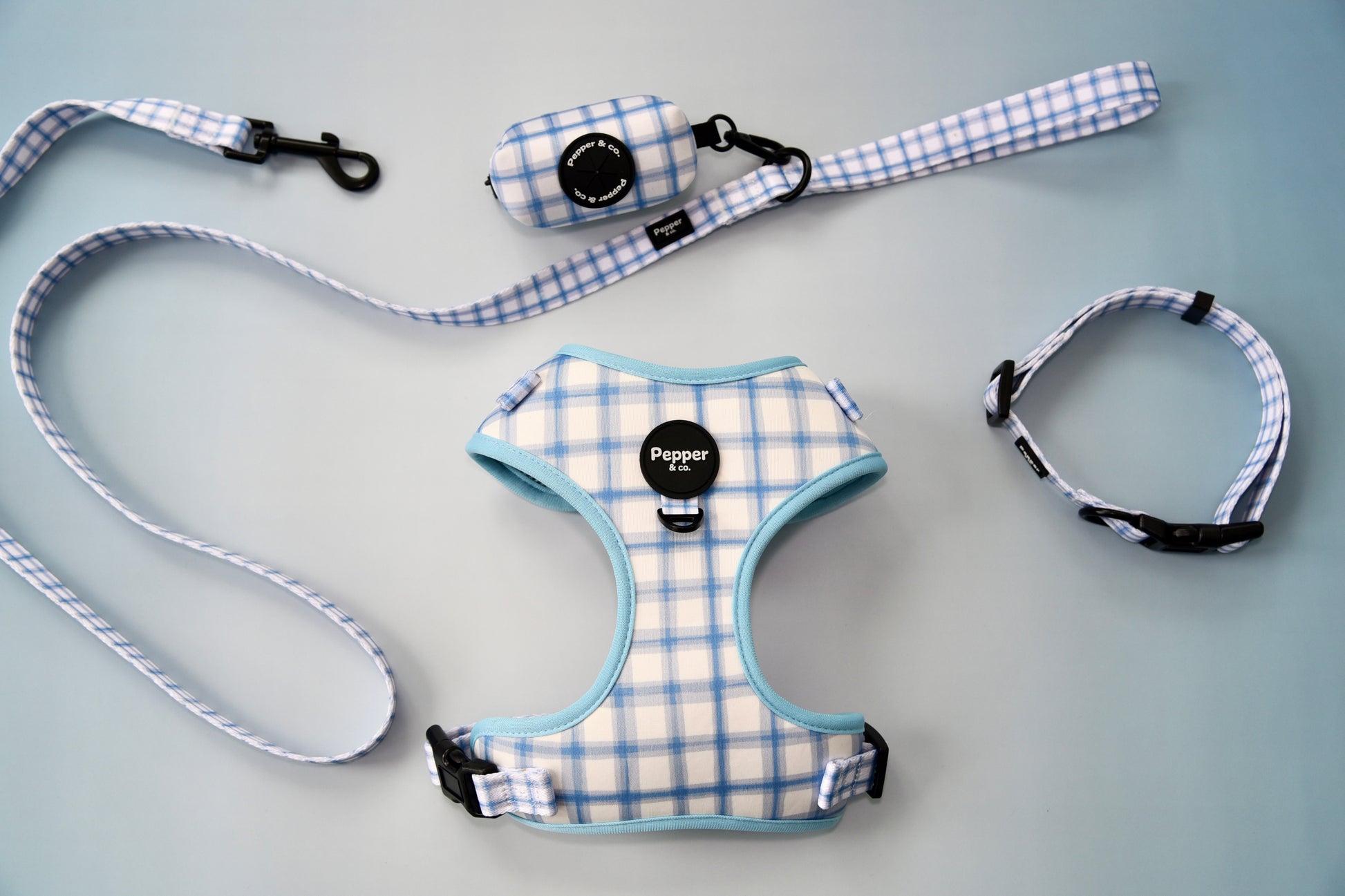 Pet harness, leash, and collar set with plaid pattern on gray background