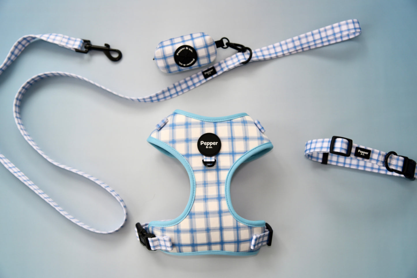 Dog harness, leash, and collar set with plaid pattern on gray background