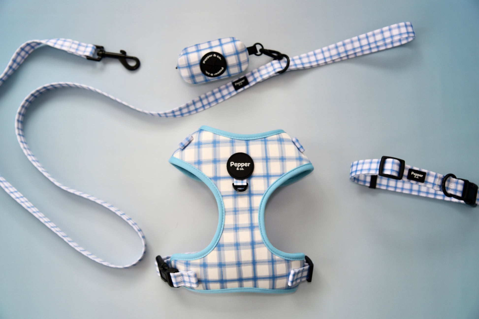 Dog harness, leash, and collar set with plaid pattern on gray background